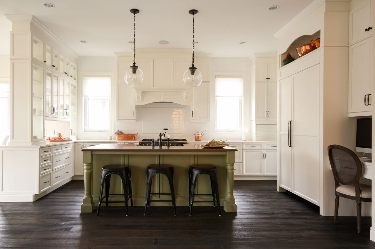 A custom kitchen with a large island and white cabinetry built by Jacob's Construction